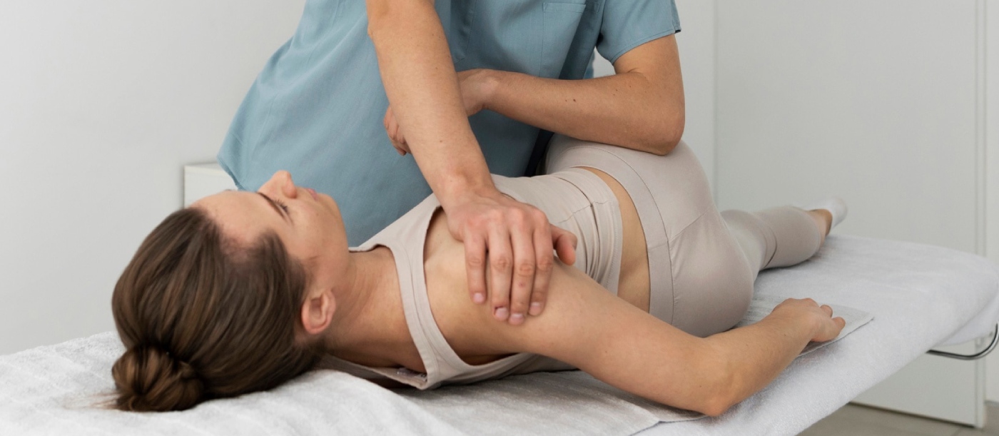fisioterapeuta empujando hombro de paciente