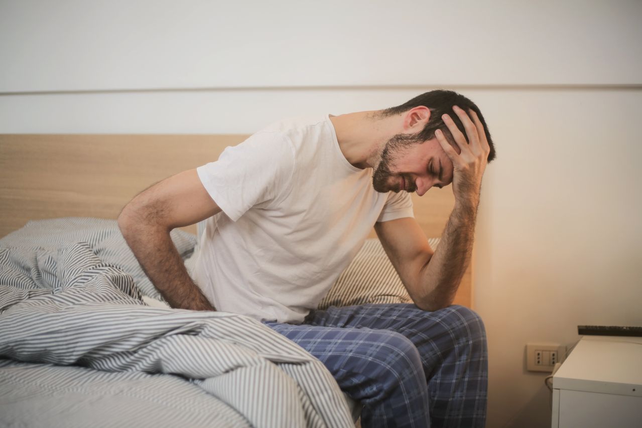 hombre en la cama doliéndose de la espalda